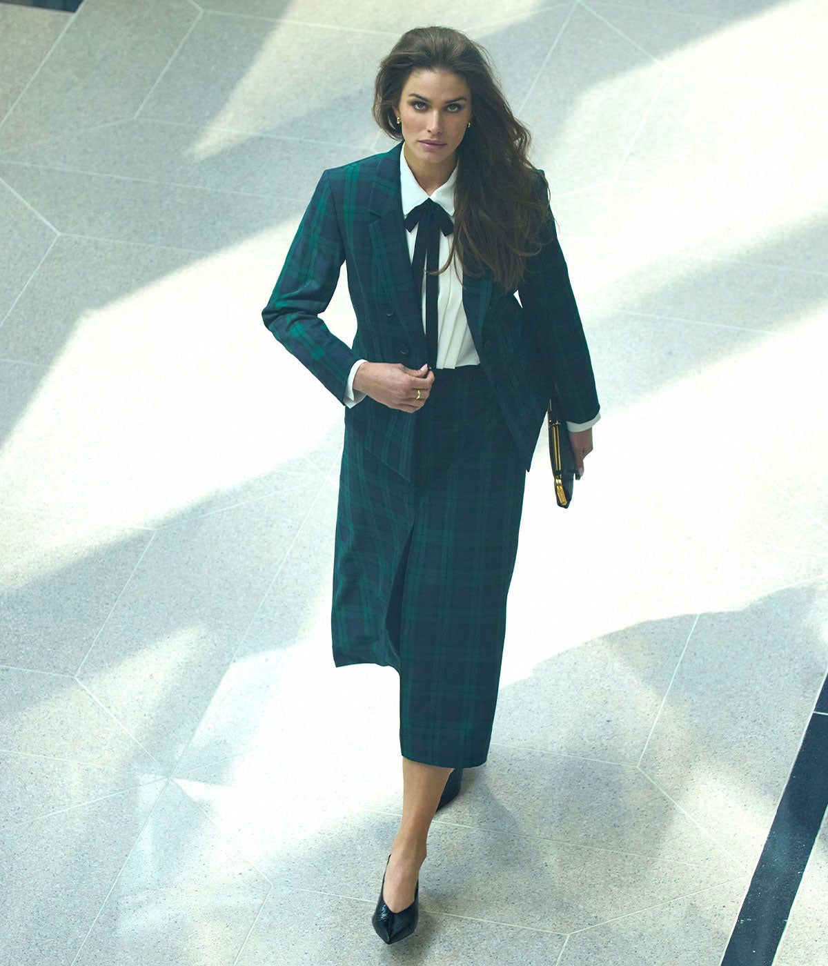 Model in a tailored Jones New York navy suit in raking sunlight
