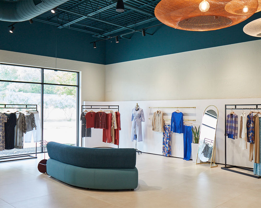 The Meison showroom — seasonal collections racked under warm pendant light